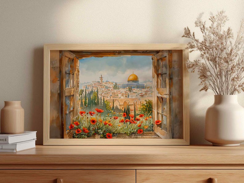 May include: Watercolor painting of a cityscape framed by a wooden window. The artwork depicts a view of a city with a golden-domed structure, red flowers, and lush greenery. The painting is displayed in a light-colored wooden frame.
