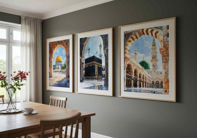 May include: Three framed watercolor prints depicting Islamic architecture. The artwork features a golden dome, the Kaaba, and a mosque with a green dome. The frames are light-colored wood, and the art hangs on a gray wall.
