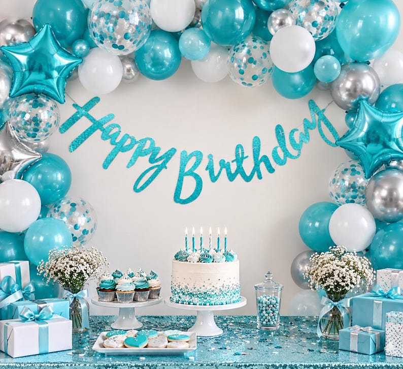 May include: A birthday party display featuring a teal glittery Happy Birthday banner, a balloon arch in teal, white, and silver, a frosted cake with teal accents, cupcakes, gift boxes, and white flowers on a teal sequined tablecloth.