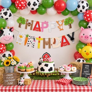 May include: A farm-themed birthday party setup featuring a balloon arch, a banner spelling HAPPY BIRTHDAY, a cow-print cake, cupcakes, and a chalkboard sign with the text OINK MOO CLUCK HAPPY BIRTHDAY and FARM FRESH BIRTHDAY FUN.