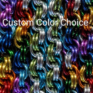 Könnte beinhalten: Nahaufnahme einer bunten Kettenhemdkette mit mehreren Strängen aus silbernen, roten, orangen, gelben, grünen, blauen und violetten Metallringen. Der Text "Custom Color Choice" ist im Bild sichtbar.