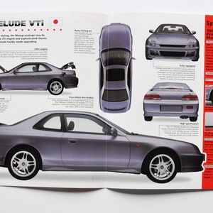 以下が含まれることがあります： 1999年型ホンダ・プレリュードVTiの雑誌ページ。車は側面、上面、前面、背面など、複数のビューで表示されています。仕様と機能は赤い文字で記載されています。車はシルバーで、アルミホイールが付いています。