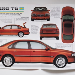 Könnte beinhalten: Eine Broschüre mit einer rostorangenen Volvo S80 T6 Limousine. Die Broschüre enthält mehrere Ansichten des Autos, darunter Front-, Heck-, Seiten- und Draufsicht, sowie Spezifikationen und Text. Das Auto hat silberne Alufelgen.