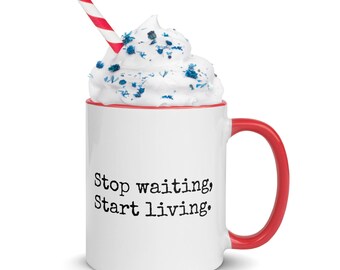 May include: White ceramic mug with a red interior and handle. The mug features the text "Stop waiting, Start living." A red and white striped straw is in the whipped cream topping, which is sprinkled with blue sprinkles.