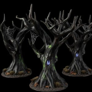 May include: Three miniature black trees with gnarled branches, textured bark, and spiderwebs. Each tree features a glowing blue oval portal in the trunk, patches of green moss, and a circular base with small tufts of brown grass and scattered leaves.