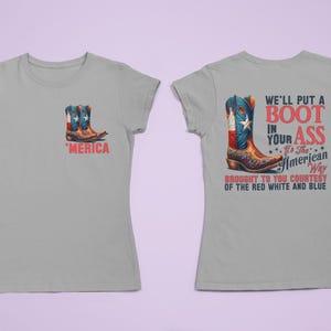 May include: A light gray t-shirt featuring a graphic of a cowboy boot with a red, white, and blue design. The front of the shirt has a small boot graphic and the word "'MERICA". The back of the shirt has the text "WE'LL PUT A BOOT IN YOUR ASS".