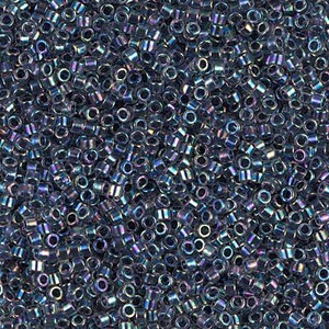May include: A close-up shot of a pile of small, cylindrical beads. The beads are a dark, iridescent color, with hints of blue, purple, and green. They appear to be made of glass or a similar material, and are used for jewelry making and crafts.