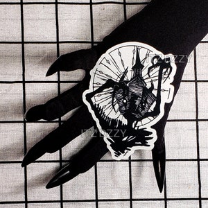 May include: Black and white sticker featuring a spooky haunted house design. The sticker has a detailed illustration of a gothic building with a tall spire, surrounded by a fence and stylized trees. The sticker has the text "ITZDZZY".