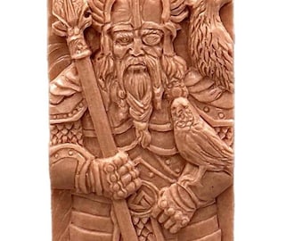 May include: A rectangular, tan-colored relief carving depicting a warrior figure with a spear, helmet, and a bird perched on his shoulder. The warrior has a long beard and is clad in armor. A second bird is perched on the warrior's other shoulder.