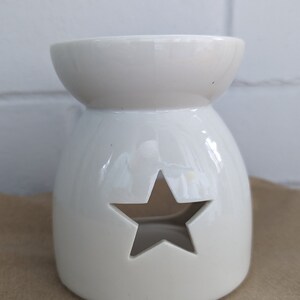 May include: White ceramic wax melt burner with a star-shaped cutout.