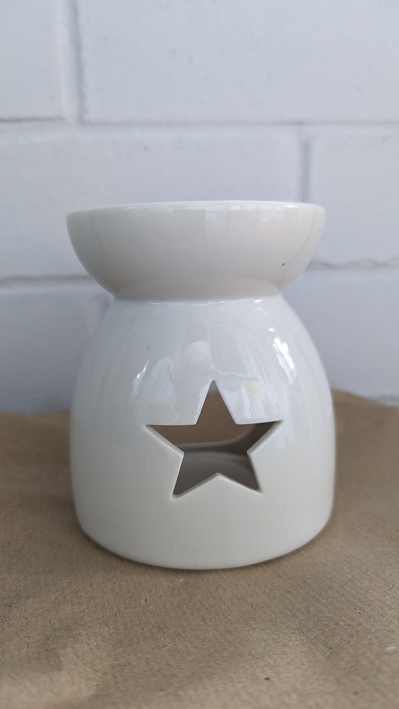 May include: White ceramic wax melt burner with a star-shaped cutout.