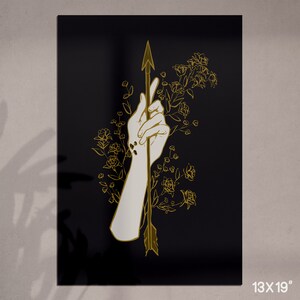 May include: A black background with a gold outline of a hand holding an arrow through the palm. The arrow is surrounded by gold outline flowers.