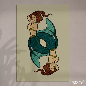 May include: A vertical print featuring two mermaids in a mirrored design. The mermaids have red hair, teal fishtails, and are wearing gold-colored tops. The print is 13 x 19 inches.