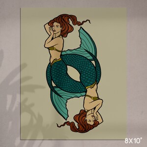May include: An 8x10 inch print featuring two mermaids in a mirrored design. The mermaids have red hair, teal fishtails, and are wearing gold-colored tops. The background is a light beige color.