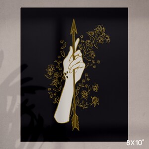 May include: A gold outline illustration of a hand holding an arrow, with floral details on a black background.