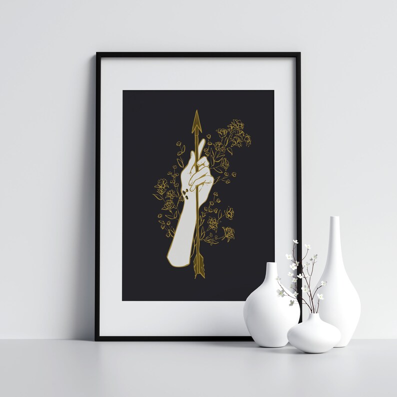May include: A black and white illustration of a hand holding a gold arrow with floral details on a black background.