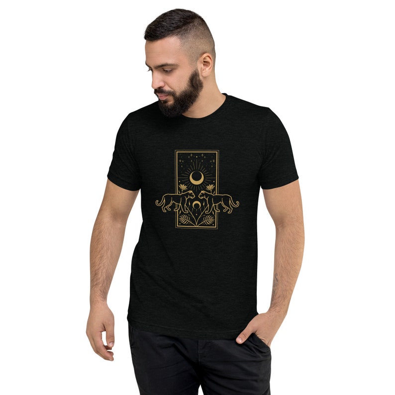 Może przedstawiać: Czarny T-shirt z złotym wzorem graficznym przedstawiającym dwie pantery zwr&oacute;cone do siebie, z p&oacute;łksiężycem i gwiazdami w tle.