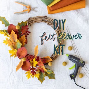 May include: A DIY felt flower kit with a grapevine wreath base, colorful felt leaves, and yellow pom-poms. The kit includes a glue gun, scissors, and felt sheets in shades of green, yellow, and orange.