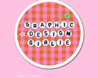 May include: A round sticker with the words "GRAPHIC DESIGN GIRLIE" in white bubble letters. The background is a pink and orange gingham pattern. The sticker has a pink border and is decorated with star and button accents.