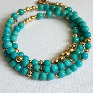 May include: A triple-strand turquoise and gold bead bracelet. The bracelet features turquoise beads of varying sizes and gold beads interspersed throughout.