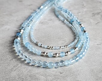May include: Three layered necklaces made of light blue aquamarine beads and silver beads.