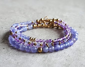 Puede incluir: Un brazalete de múltiples hilos con cuentas de amatista y piedras preciosas azules, separadas por cuentas doradas.