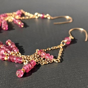 Puede incluir: Un par de pendientes de oro con cuentas de piedras preciosas rosas. Los pendientes tienen un dise&ntilde;o de cadena con m&uacute;ltiples hileras de cuentas.