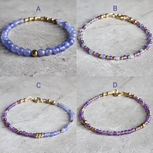 May include: Four bracelets with gold clasps and purple and blue gemstone beads. The bracelets are labeled A, B, C, and D.