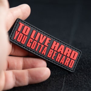 May include: Black and red morale patch with the text "To Live Hard You Gotta Be Hard".