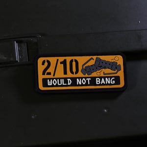 Op de afbeelding: Een gele patch met zwarte tekst en een afbeelding van een gebroken ketting. De tekst luidt "2/10 Would Not Bang".