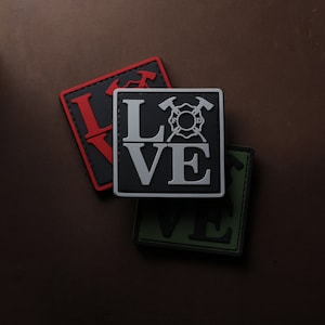 May include: Three black, red and green patches with the word "LOVE" in white letters. The middle patch features a firefighter's crossed axes and helmet emblem.