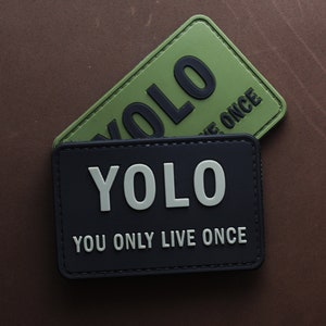 May include: Two black and green patches with the text "YOLO" and "YOU ONLY LIVE ONCE" on them.