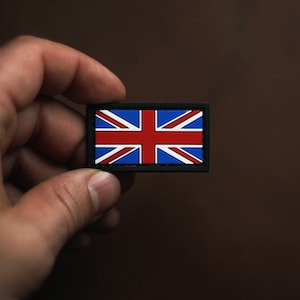 Peut inclure: Un petit patch noir avec un motif de drapeau Union Jack rouge, blanc et bleu.