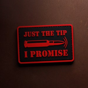Può includere: Toppa nera e rossa con il testo "JUST THE TIP I PROMISE" e una silhouette rossa di un proiettile.