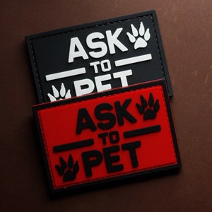 Puede incluir: Dos parches negros y blancos con el texto "Ask to Pet" y una huella de pata. El parche superior es negro con texto blanco y el parche inferior es rojo con texto negro.