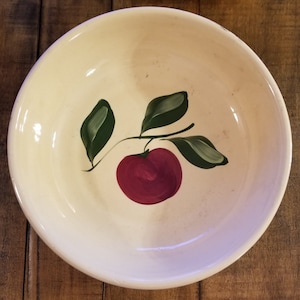 May include: A white ceramic bowl with a hand-painted design of a red apple with green leaves.