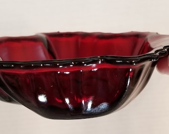 May include: A deep red glass bowl with a scalloped edge and a fluted design. The bowl is made of ruby red glass and has a shiny finish.