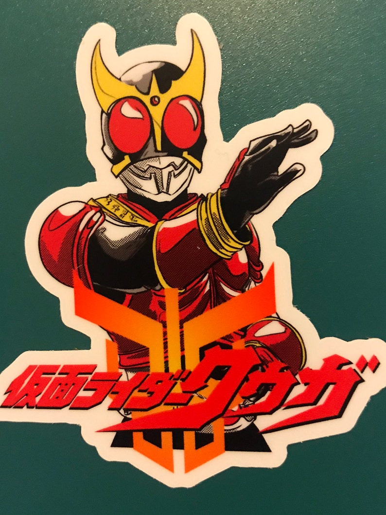 May include: A sticker featuring a red and black character with a gold helmet and red eyes. The character is posed with one arm extended. The sticker has Japanese text in red and orange.