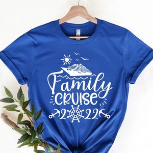 Puede incluir: Una camiseta azul real con un diseño gráfico blanco de un crucero, sol, pájaros y el texto "Family Cruise 2022".