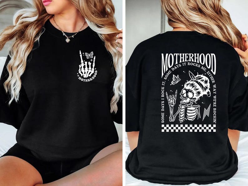 May include: Black t-shirt with a white graphic print of a skeleton hand with a butterfly and the text "Motherhood" on the front. The back of the shirt has a white graphic print of a skeleton with a butterfly and the text "Motherhood Some days I rock it, some days it rocks me either way we're rockin'"