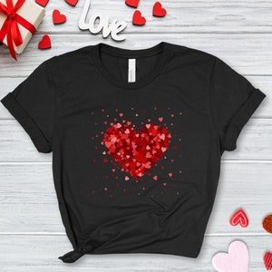 May include: Black t-shirt with a red heart made of smaller red hearts. The heart is surrounded by smaller red hearts scattered around it.