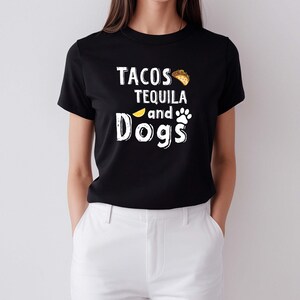 May include: Black t-shirt with white text that reads "Tacos Tequila and Dogs" with a taco and paw print graphic.