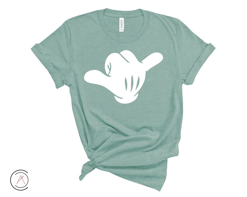 May include: A teal blue t-shirt with a white hand making the shaka sign.