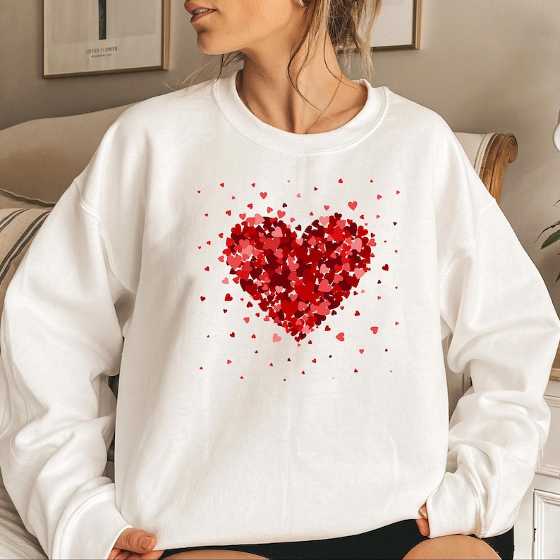May include: White sweatshirt with a red heart made of smaller hearts printed on the front.