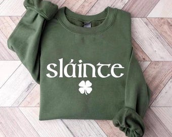 May include: A green sweatshirt with a white shamrock and the word "sláinte" printed on the front.