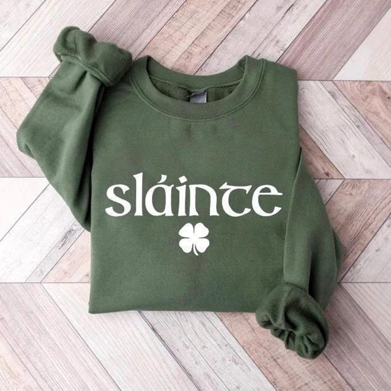 May include: A green sweatshirt with a white shamrock and the word "sl&aacute;inte" printed on the front.
