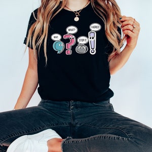 May include: Black t-shirt with a graphic of punctuation marks with faces and speech bubbles. The speech bubbles say "Wait", "What?", "Stop it", and "I agree!"