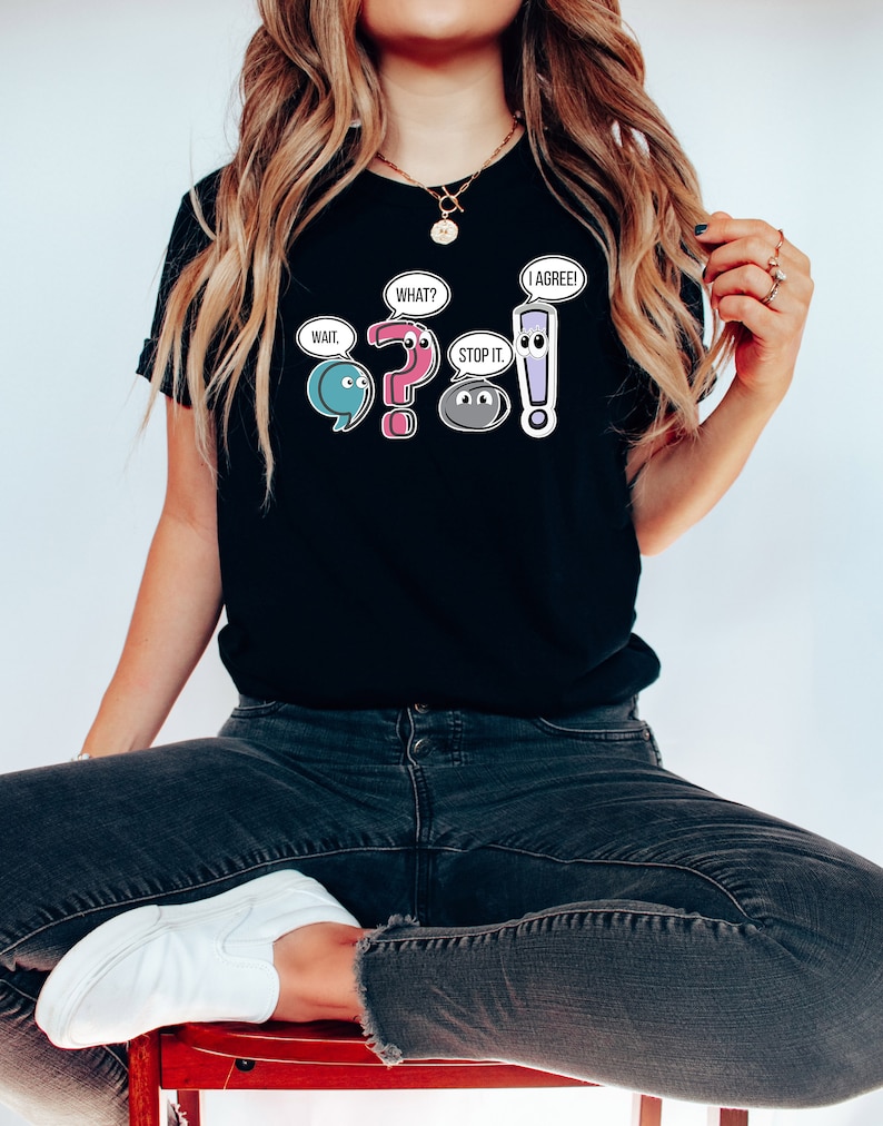 May include: Black t-shirt with a graphic of punctuation marks with faces and speech bubbles. The speech bubbles say "Wait", "What?", "Stop it", and "I agree!"