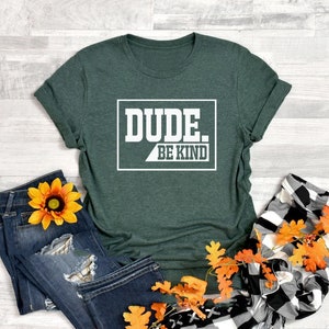 May include: A green t-shirt with the text "DUDE. BE KIND" in a white box.