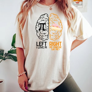 May include: A white t-shirt with a black and orange brain graphic. The left side of the brain has a pi symbol and the text "LEFT I LOVE PI". The right side of the brain has a slice of pie and the text "RIGHT DID SOMEONE SAY PIE?"